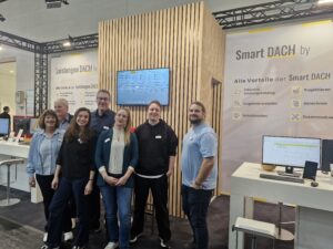 Sechs Junge Mitarbeiter der A. Icking GmbH präsentieren sich vor dem messestand auf der Dach+Holz .
